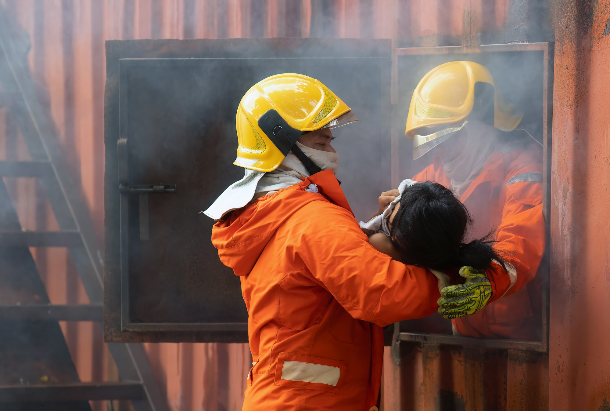 Fire fighting team rescue life saving young girl from fire burn and handover child through window